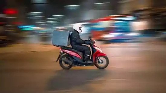 Delivery man falls from bike in waterlogged street