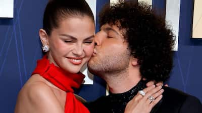 Selena Gomez and Benny Blanco brought romance on the red carpet at the 77th Primetime Emmy Awards. Looking radiant in red, the Louis Vuitton red gown added radiance to Selena's red carpet appearance. Selena was joined on the red carpet by her fiance, American music producer and songwriter Benny Blanco, who planted a kiss on Selena's cheek making the Only Murders In The Building actress blush. The colour definitely matched her red haute couture piece! Benny matched Selena's energy in a black tuxedo paired with an embellished tonal sheer shirt. The black and red combination complemented the couple's style quotient.