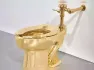 A solid gold, flushable toilet sculpture titled 