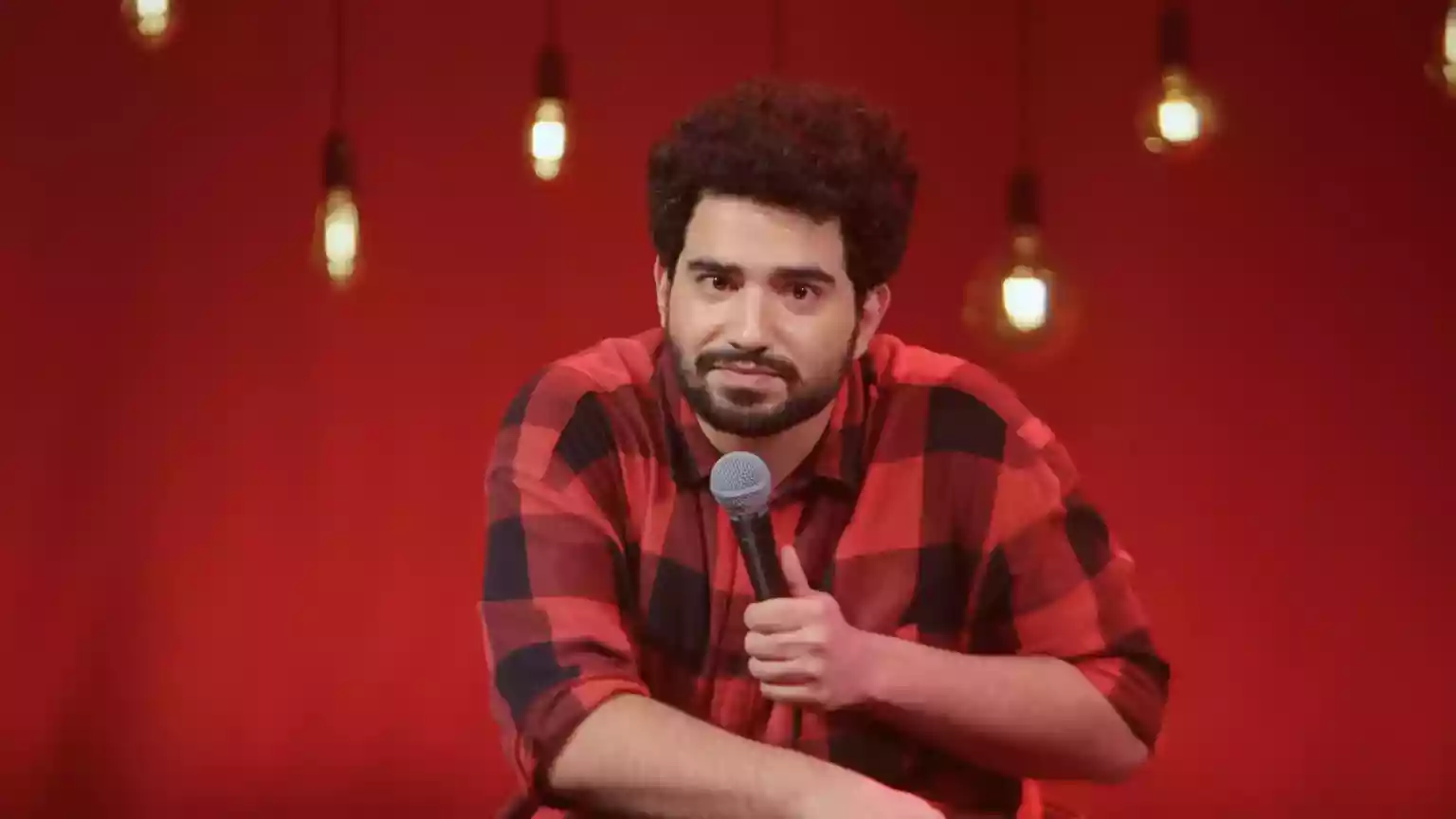 In an Indian city, an unassuming, slightly rumpled comedian walks into the spotlight for the first time in months. Tousle-haired and clad in a checked shirt