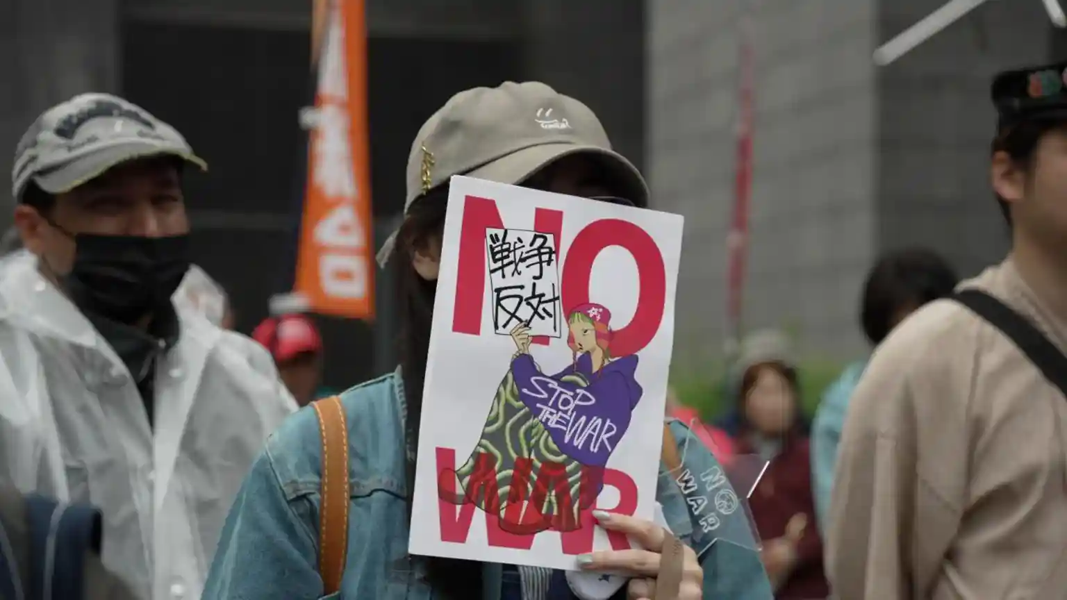 On a Tokyo street corner, in the pouring rain, a swelling crowd gathered with drenched placards and sodden flags. On one of them was written just two words