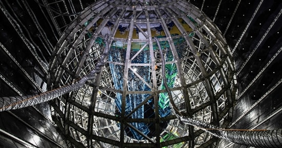 At the foot of the thickly forested Dashi Hill, in southern China's Guangdong province, pre-approved visitors can take a ride aboard a unique yellow train. Rather than winding through the serene landscape, however, the train descends along a steeply-sloping track that disappears into the darkness under the mountainside. After ten minutes on the train and a few more on foot, visitors reach a vast chamber that has been gouged out of the Earth. Here, more than half a kilometre underground, is a 12-storey-high sphere made from steel and plexiglass—the Jiangmen Underground Neutrino Observatory (JUNO).
