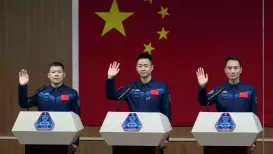 Three Chinese astronauts returned to Earth on Friday, state TV footage showed, after a delay caused by their spacecraft being struck by debris in orbit