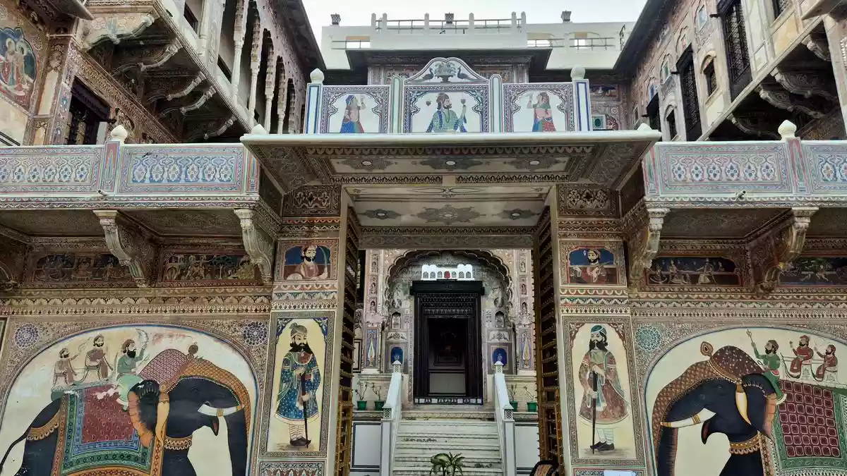 “This haveli is at least a hundred years old, so are the frescos in your room,” the bellman tells me proudly as he opens the low-hung wooden door that