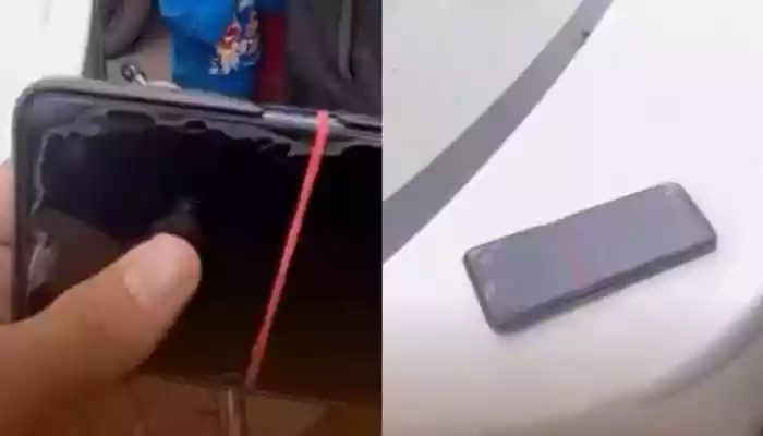 In the video, the father can be seen holding his old phone, its screen damaged, with a rubber band around it, and worn out from years of use