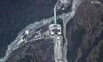 A dark wall appears from behind the buildings at Gyirong, on the Chinese side of the Nepal-Tibet border. At first, it looks almost like a black cloud