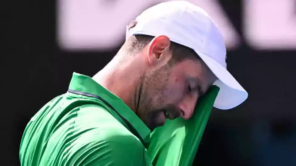 Novak Djokovic's bid to make more tennis history is still alive as he scraped into the Australian Open semi-finals after Lorenzo Musetti retired injured when