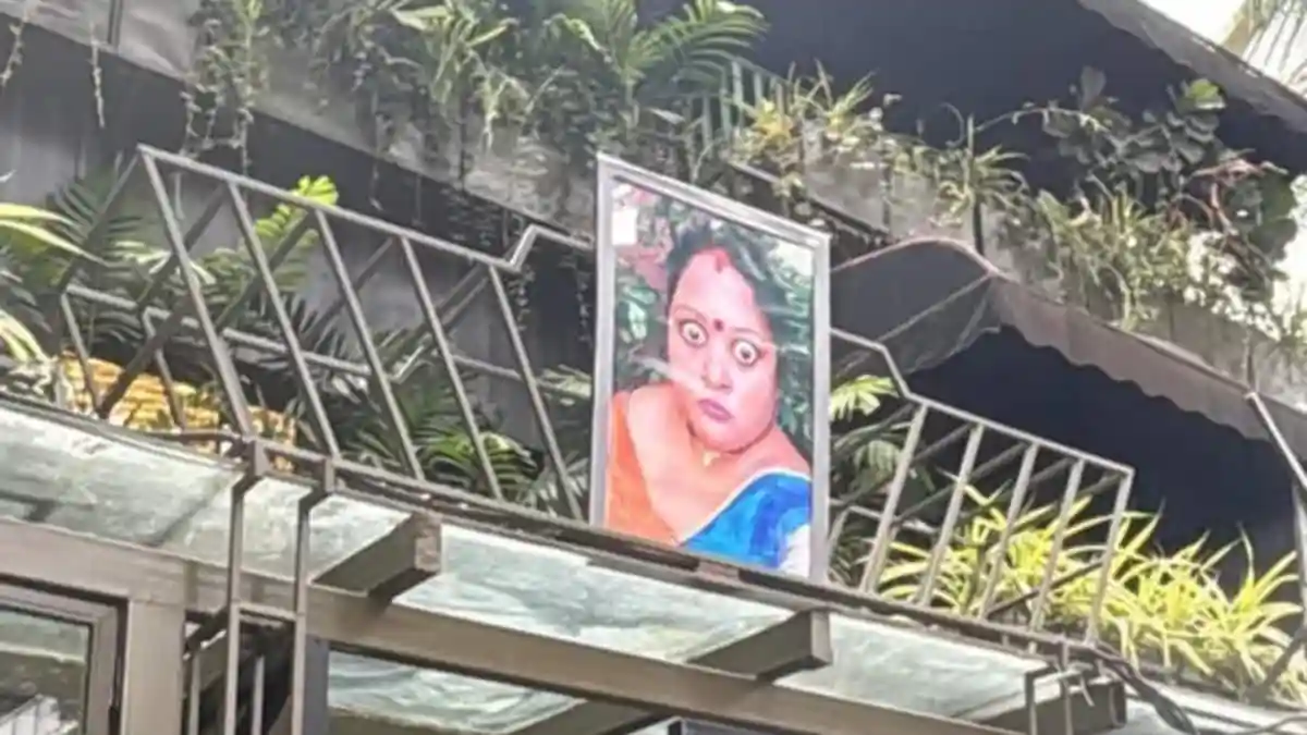 It is not unusual to come across funny or random photos displayed on shops or walls while walking through busy city streets. One such image recently caught a passerby's attention in Bengaluru, leaving him both amused and curious. The photo, shared by a Reddit user, sparked a flurry of reactions online after he posted about his unexpected find.It is not unusual to come across funny or random photos displayed on shops or walls while walking through busy city streets. One such image recently caught a passerby's attention in Bengaluru, leaving him both amused and curious. The photo, shared by a Reddit user, sparked a flurry of reactions online after he posted about his unexpected find.The image shows a framed picture of a woman with wide, staring eyes fixed above the entrance of a closed pub in Koramangala. The sight looks unusual amid the greenery and modern building design, instantly standing out to anyone passing by. The user explained that he had also spotted similar photos outside shops in the Peenya area and wondered what they meant.