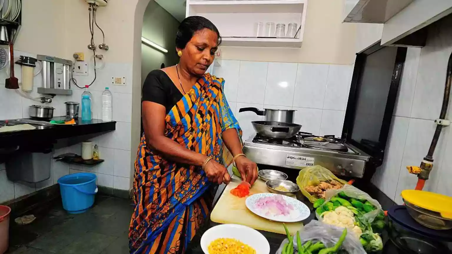 On a Tuesday afternoon in Noida, near the Indian capital Delhi, Seema Kumari* arrives in a purple T-shirt and gets straight to work. Kitchen counters are wiped